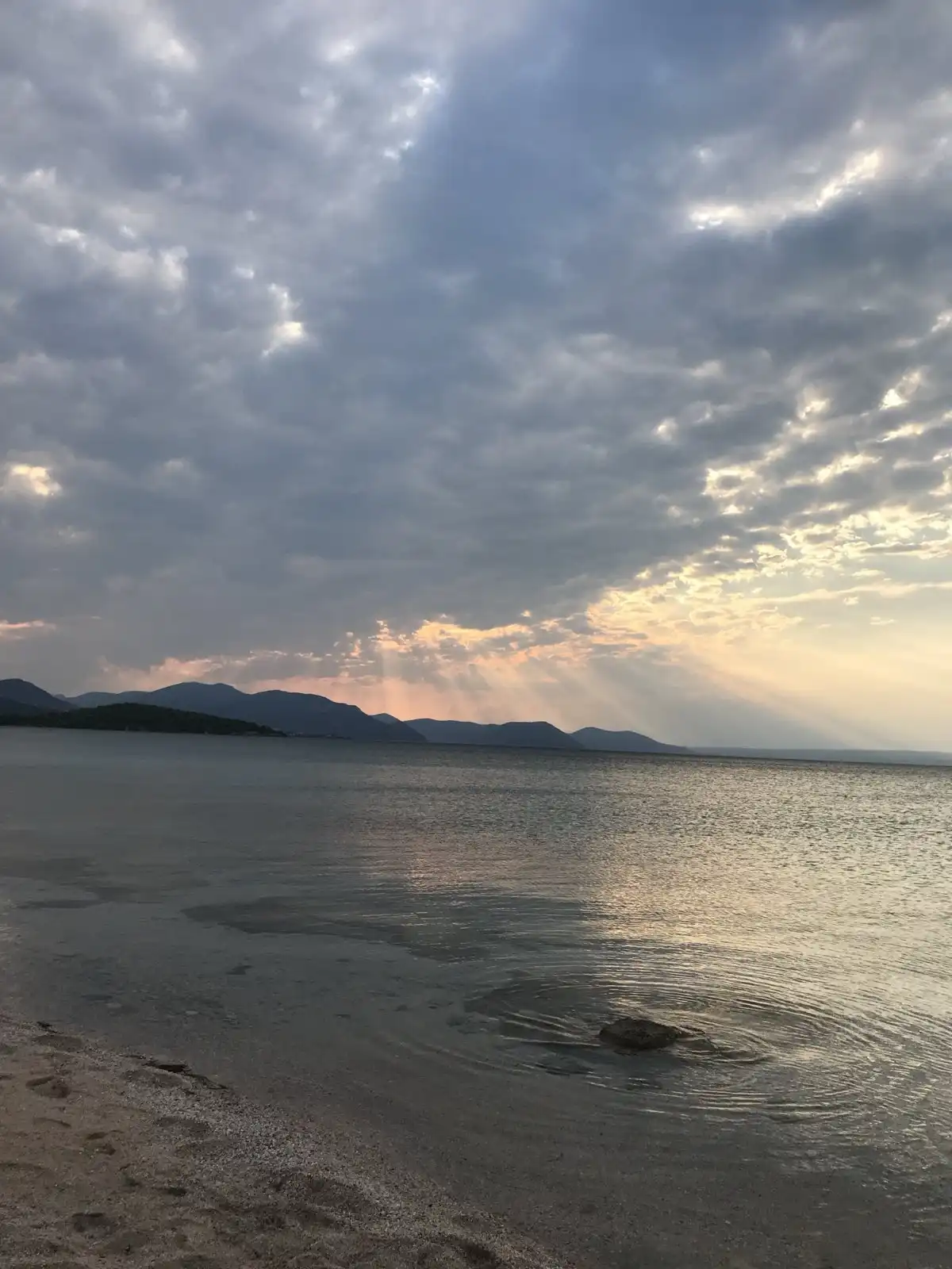 Dramatic sky with clouds reflecting on the wet sand of a beach